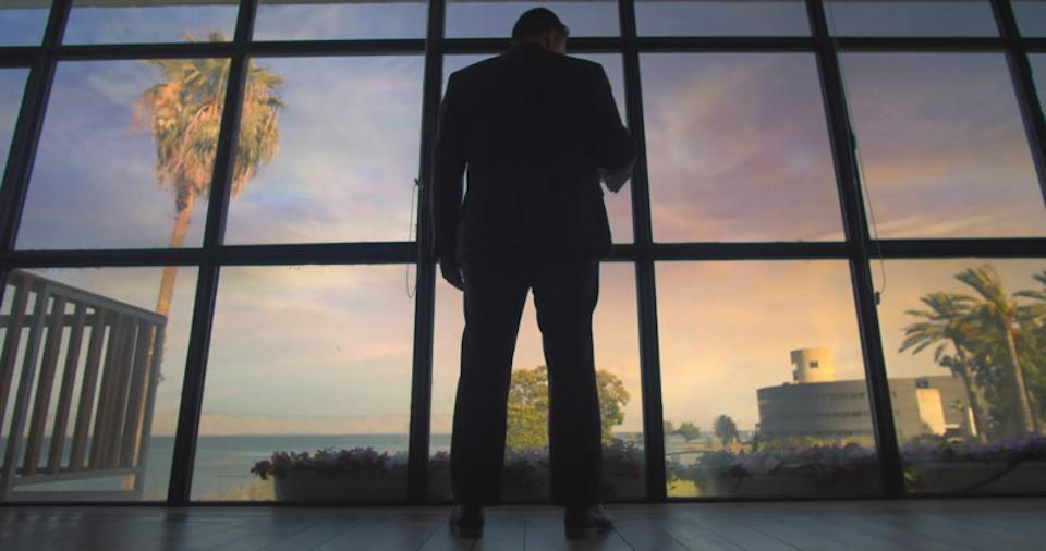 High above the city, at the glass, sunset