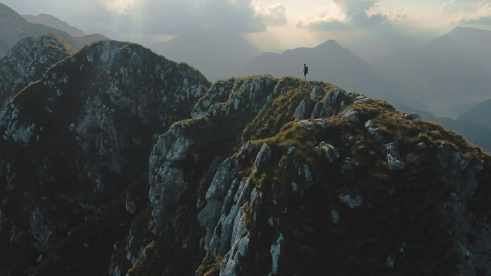 Held long: a small figure in the mountains, from above