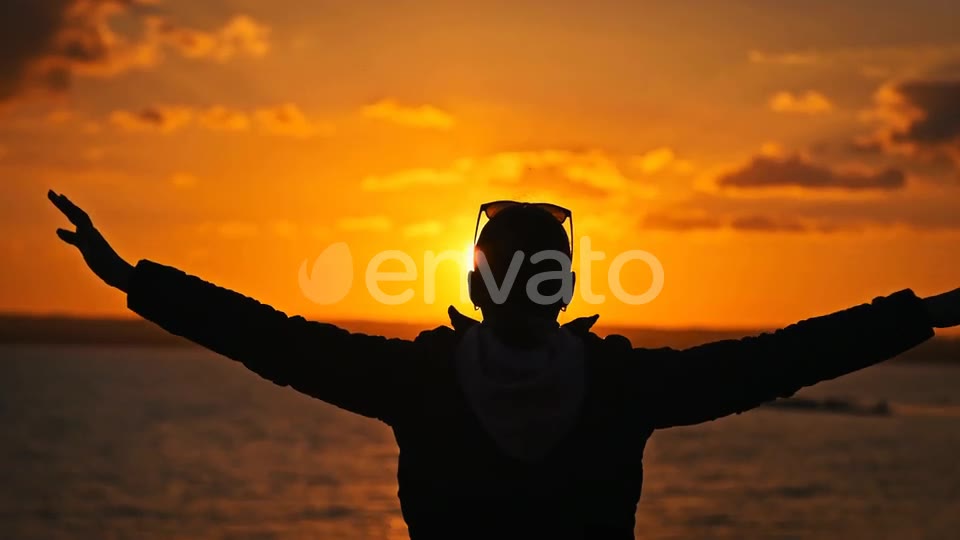 Hands still up, he opens to the sun and the light takes the frame
