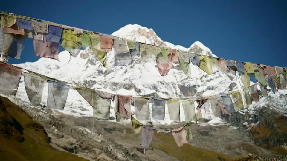 Prayer flags in the wind, under the snow peaks