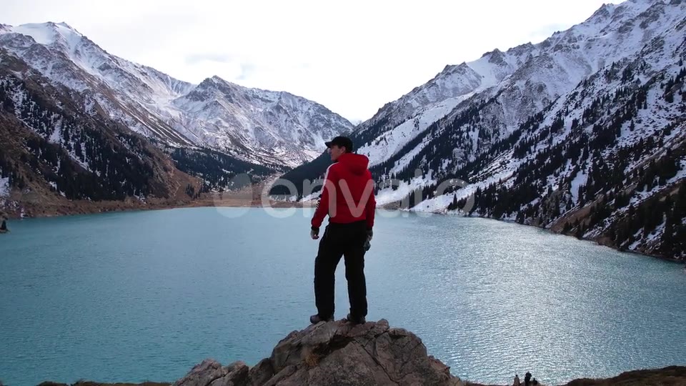 By the mountain lake, the camera circling him