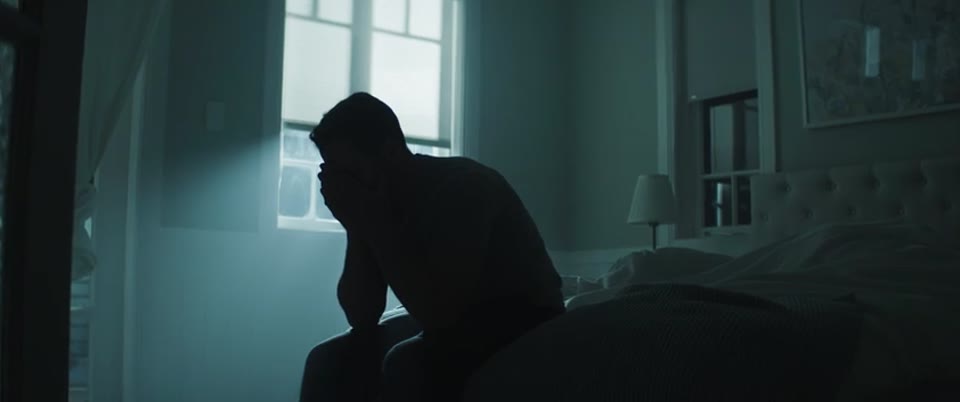 In silhouette, alone in the house, his head in his hands. Then straight out into the open