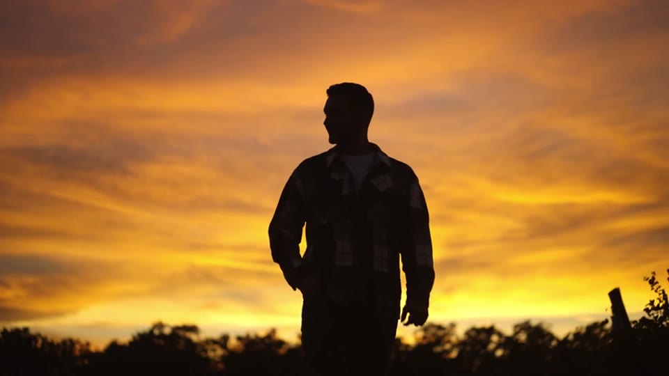 The same man, the same sky, closer. He turns his head once, then stays