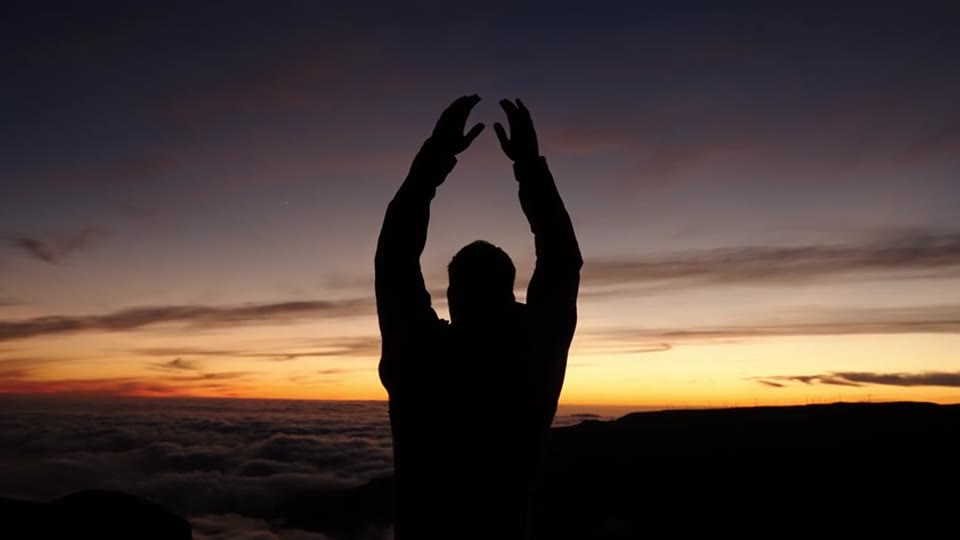 The same shot: hands still up, reaching into the last light
